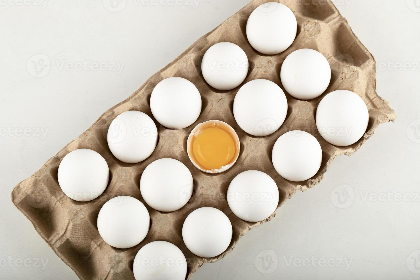 Raw chicken eggs in a carton container photo