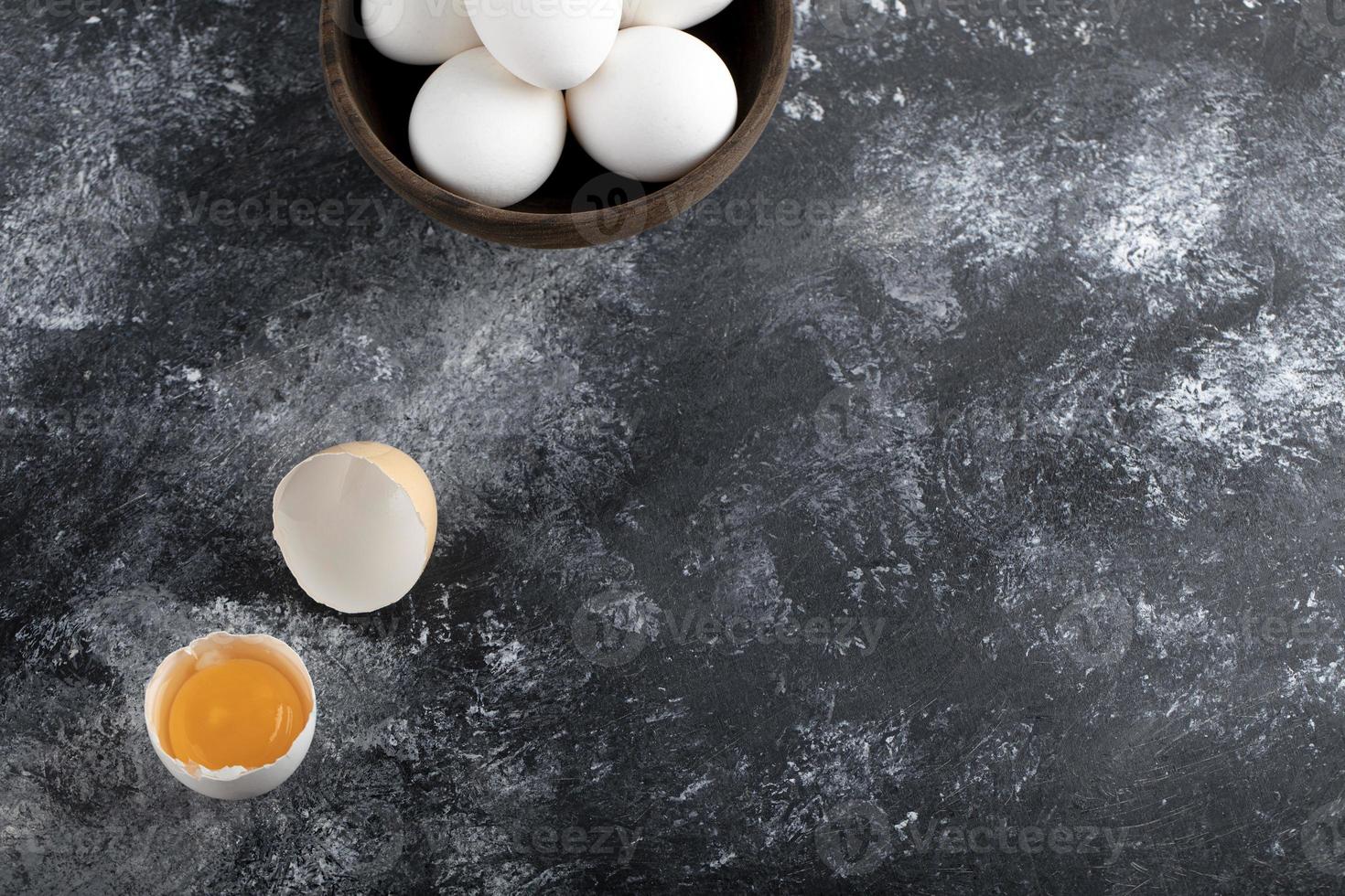 Cuenco de huevos blancos y yema sobre un fondo de mármol foto