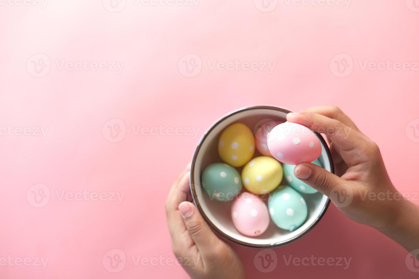 mano del niño recogiendo coloridos huevos de pascua foto