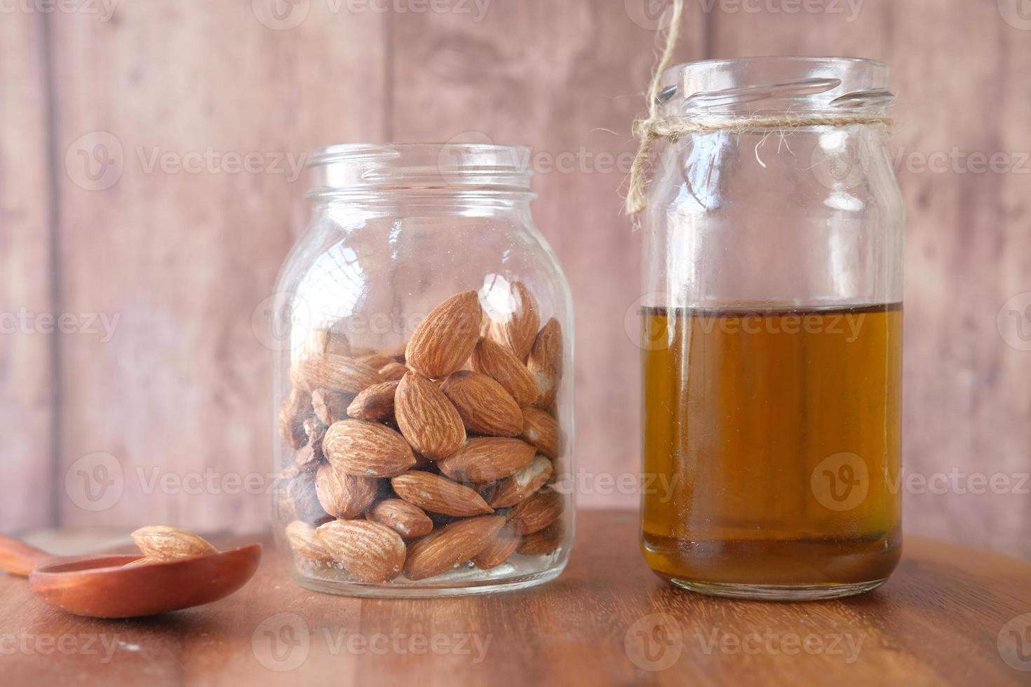 Almond oil in bottle on wooden background photo