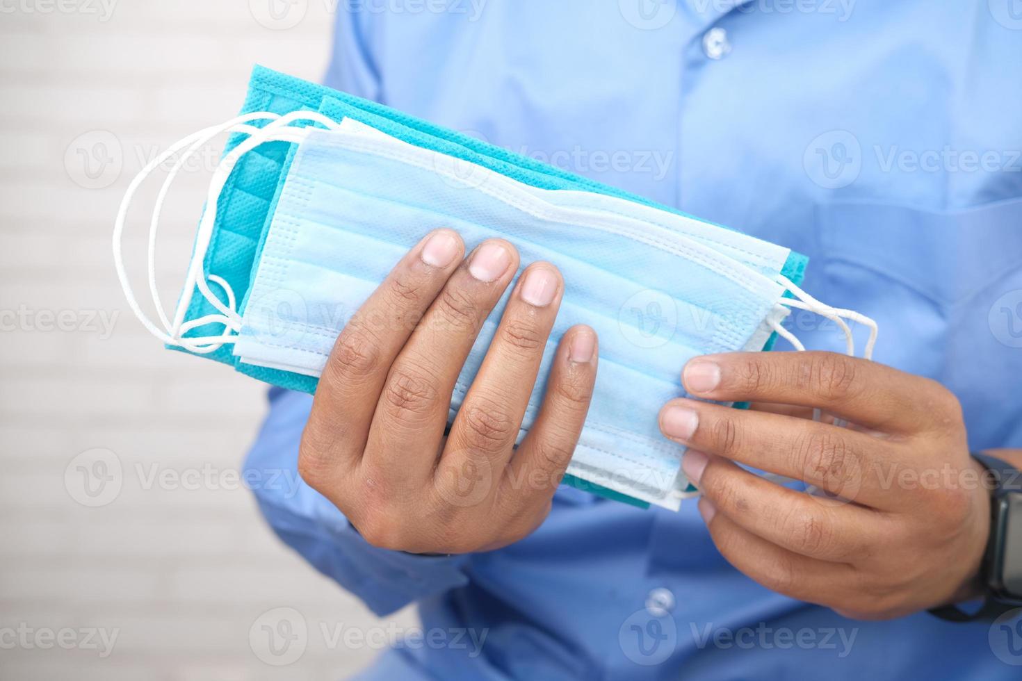 Man hand holding surgical face masks, close up photo