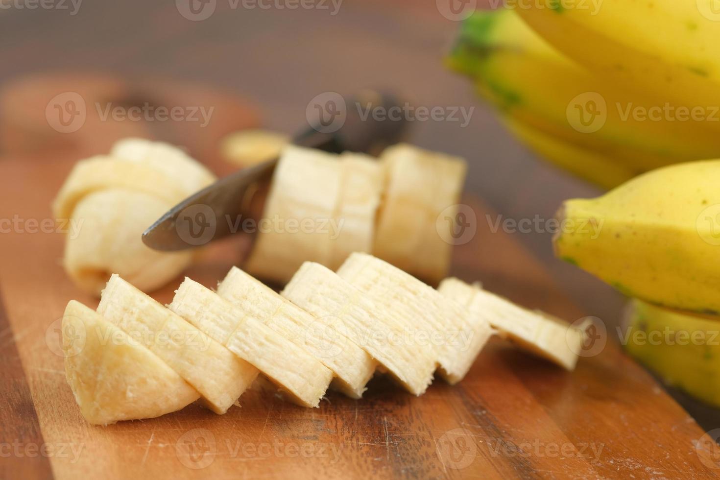 Cerca de plátano en rodajas sobre una tabla de cortar foto