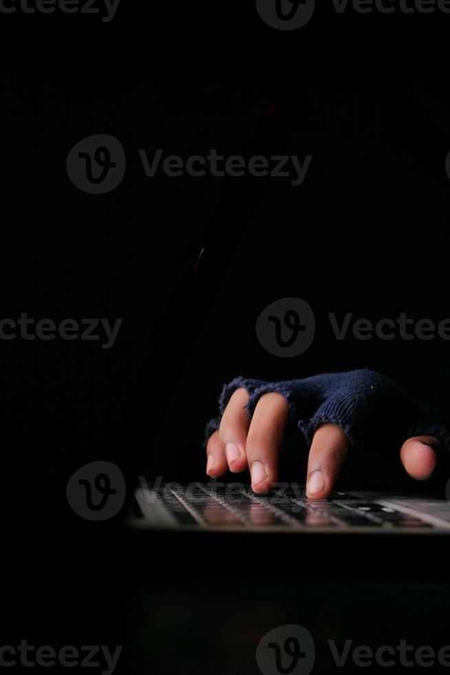 Hand isolated on black background using computer keyboard photo