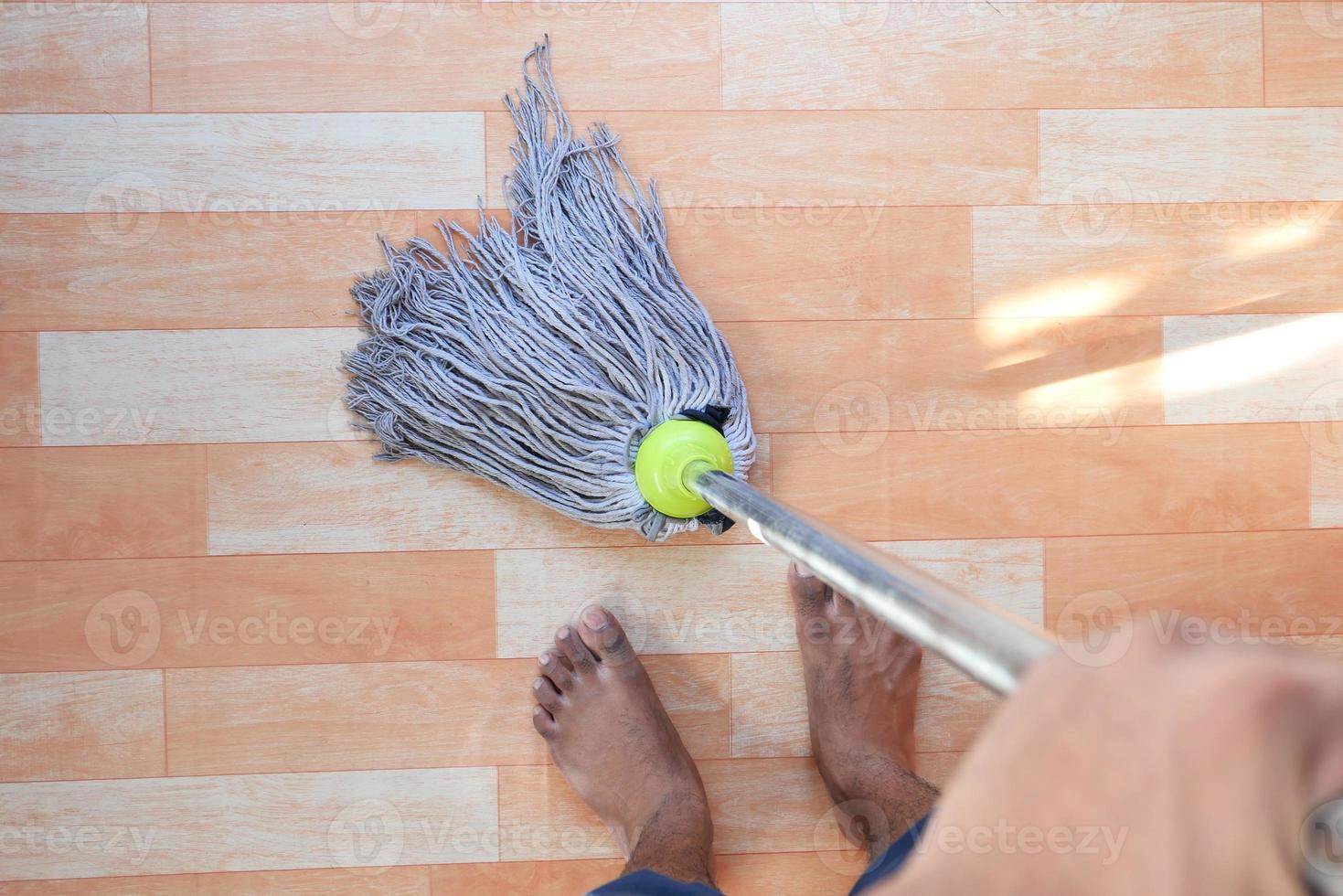 hombre trapeando un piso de madera foto