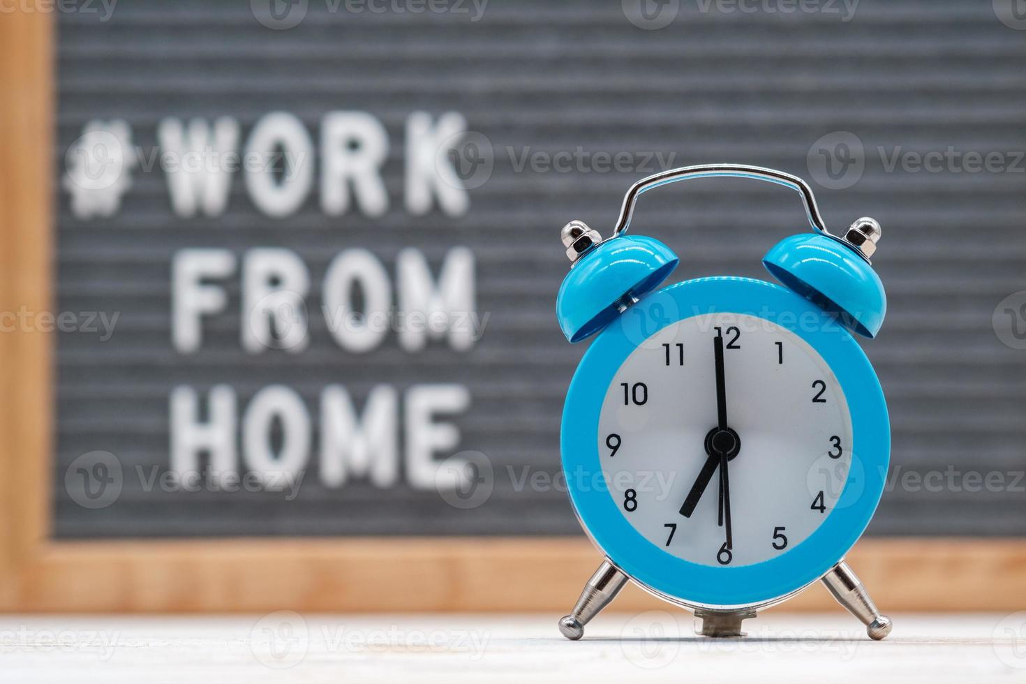 Vintage alarm clock on the background of english text that says work from home photo