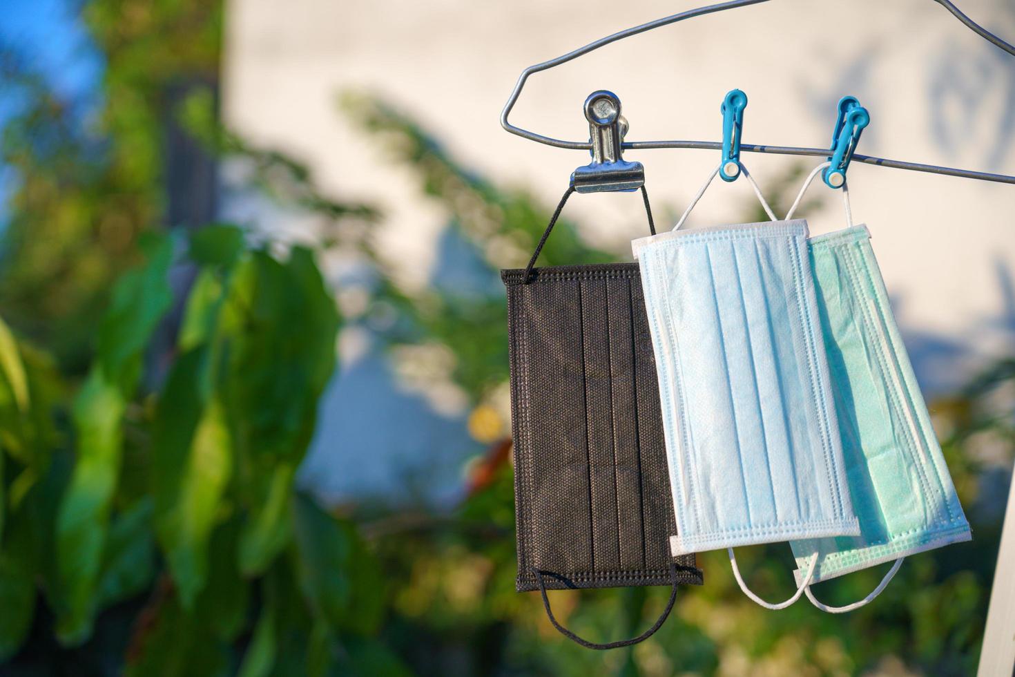 Recycled surgical face masks drying in the sun after cleaning photo