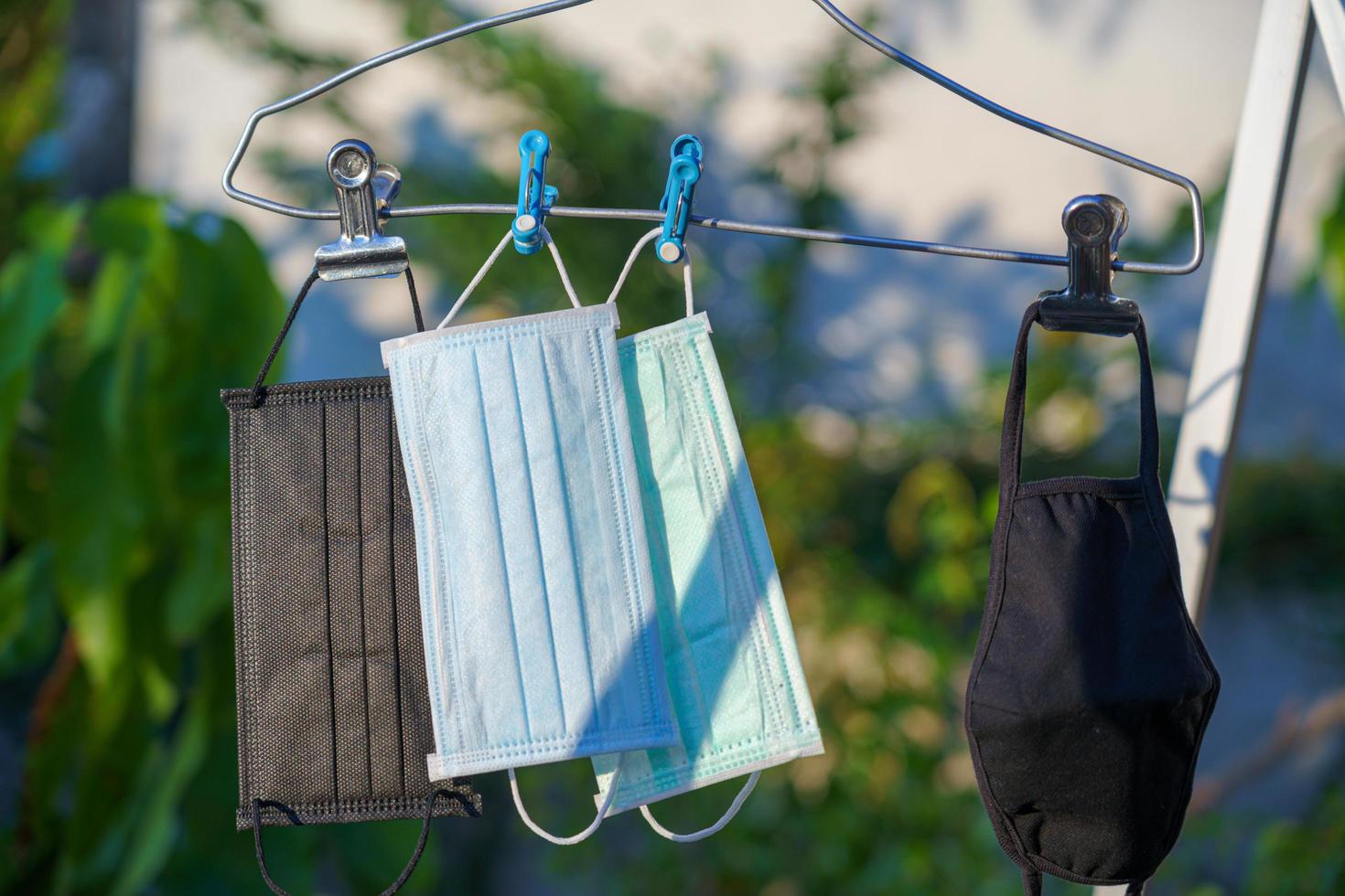 Recycled face massk on hangers drying in the sun after cleaning photo