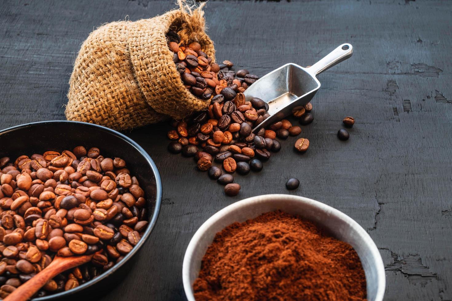 granos de café y café molido en una mesa oscura foto