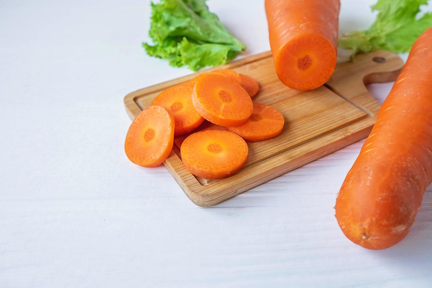 Sliced carrots on a wood board photo