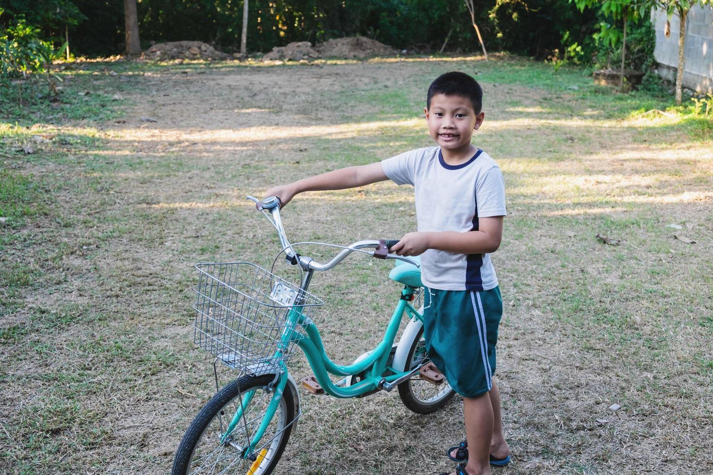 niño caminando con una bicicleta foto