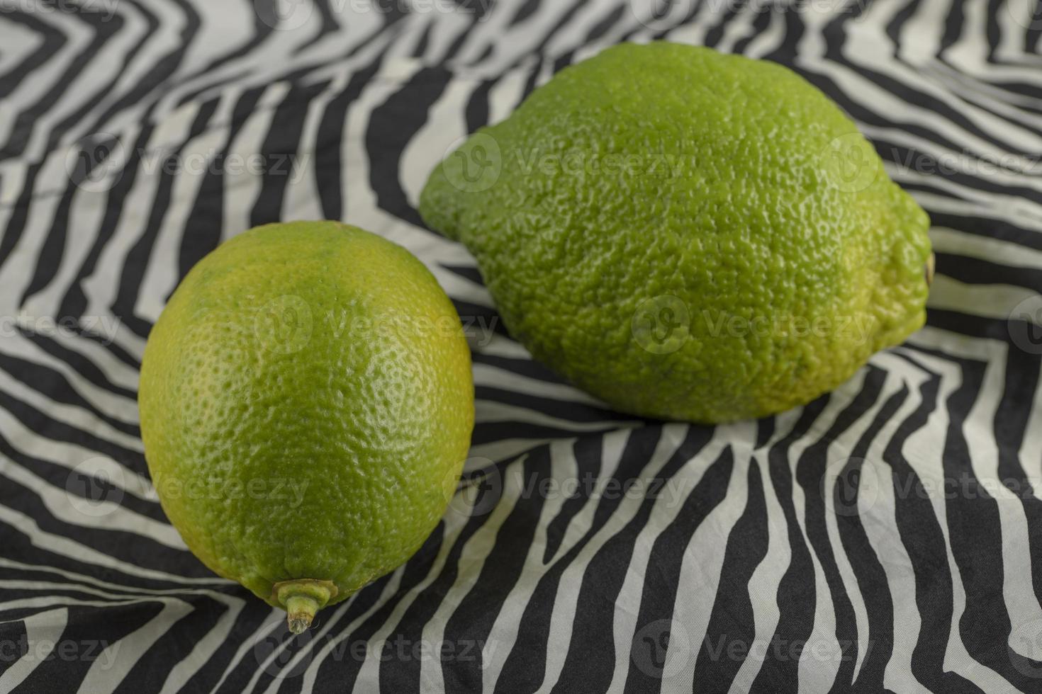 Green lemons on a tablecloth photo