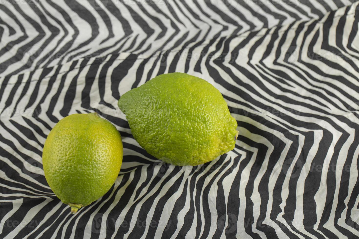 Green lemons on a tablecloth photo