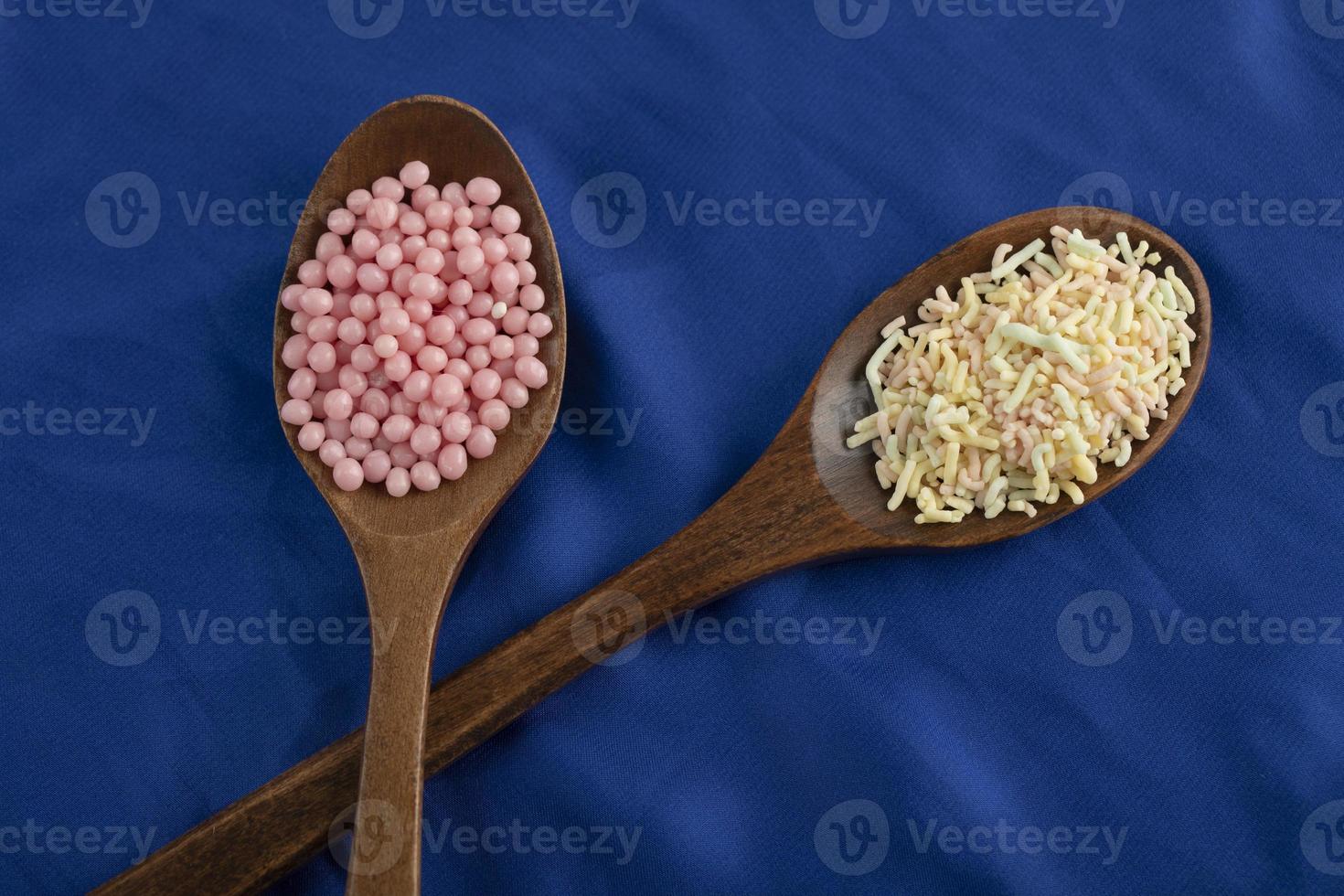 Wooden spoons full of colorful sprinkles photo