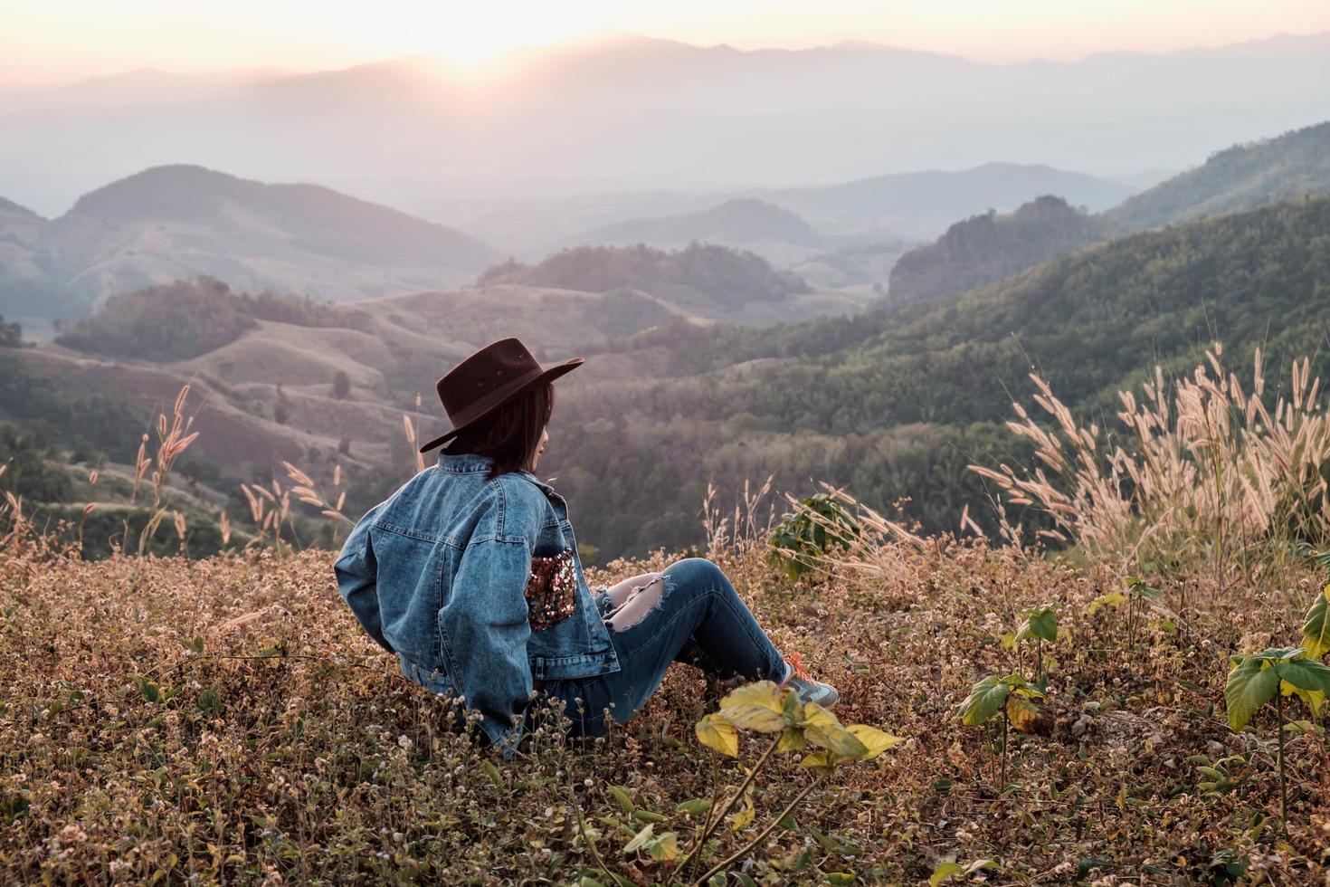 mujer sentada en una montaña foto