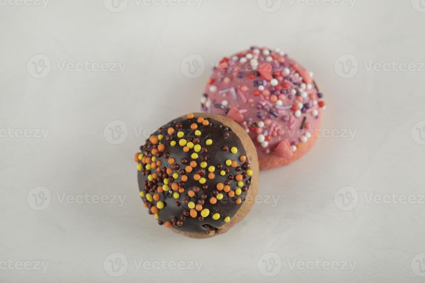 donas pequeñas de chocolate dulce de colores con chispitas foto