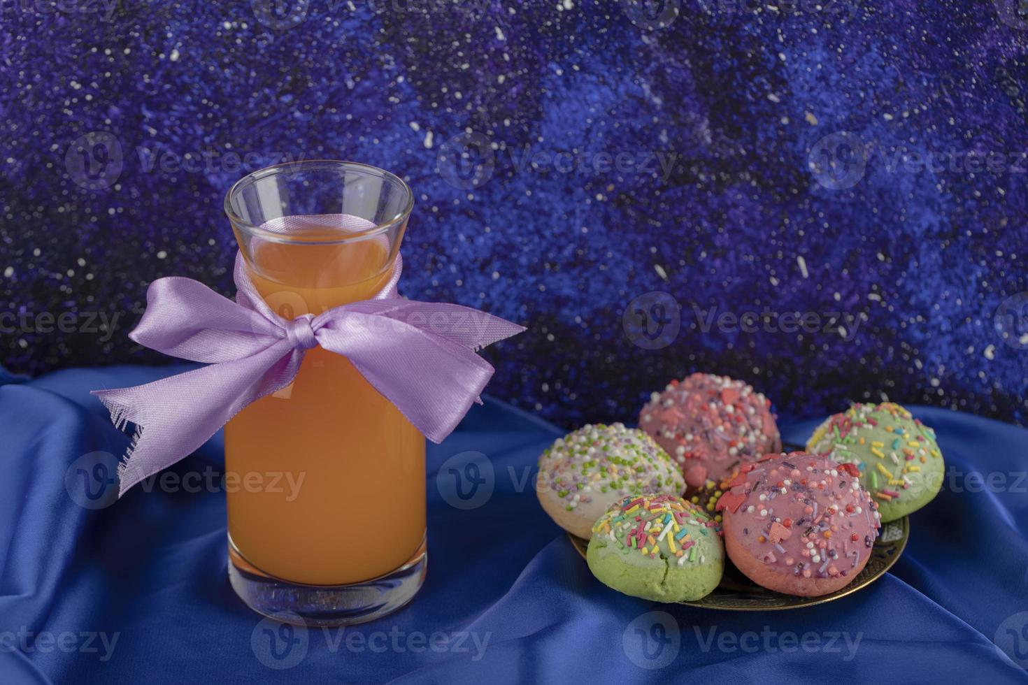 colorido juego de dulces rosquillas pequeñas con un tarro de jugo de vidrio foto