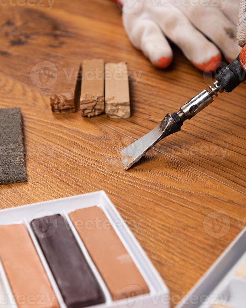 Vertical view of a restoration repair of laminate parquet with wax photo