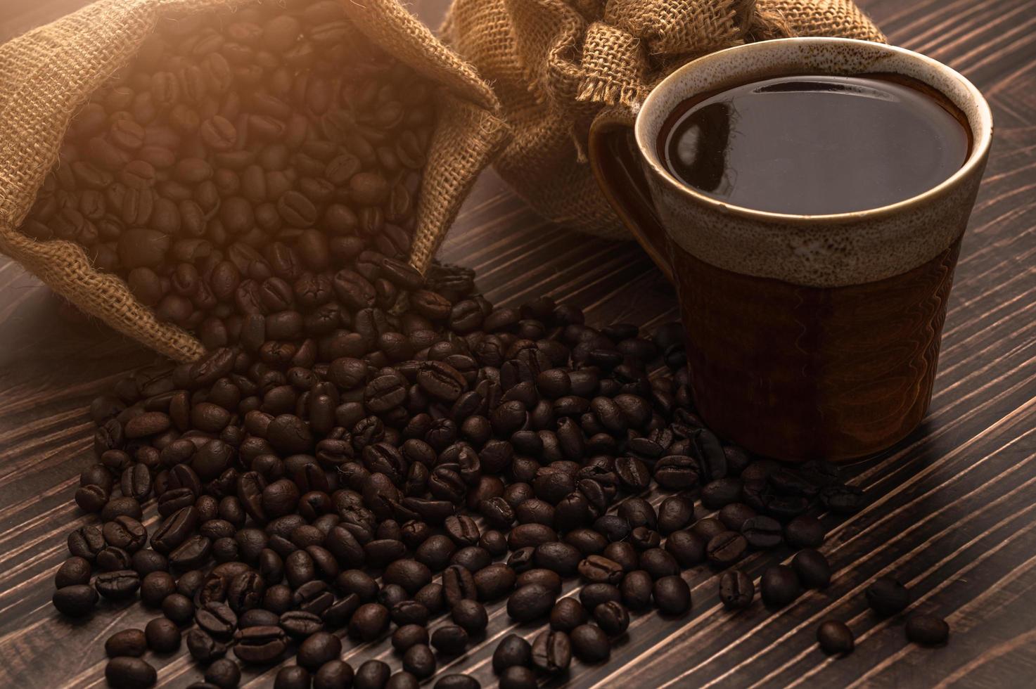 una taza de café y granos de café en una mesa de madera, amor concepto de café foto