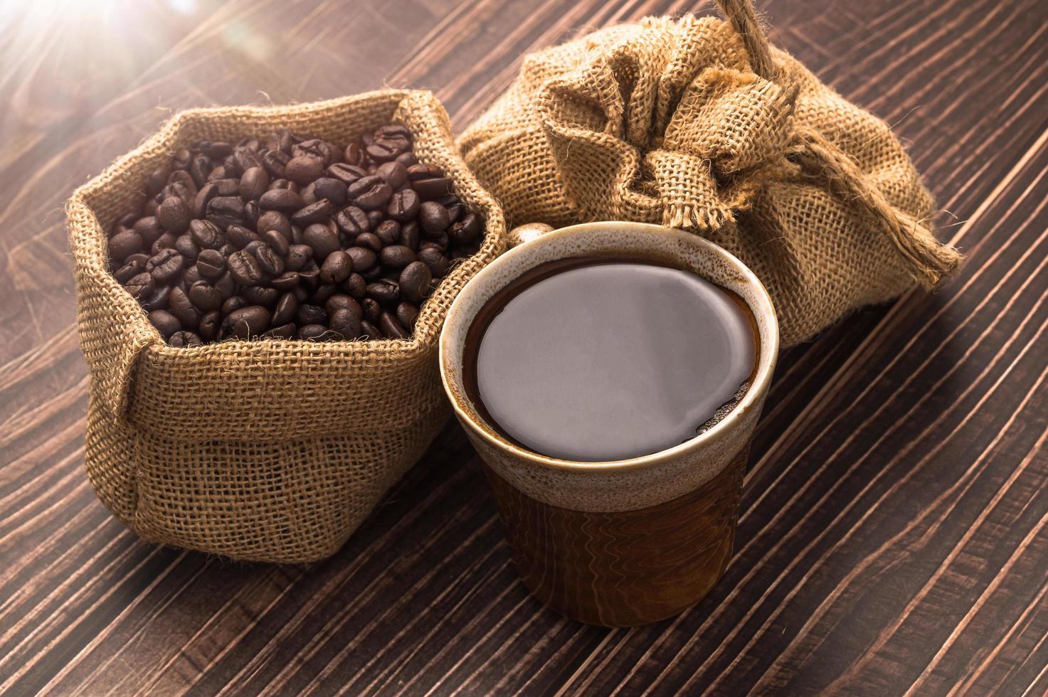 una taza de café y granos de café en una mesa de madera, amor concepto de café foto