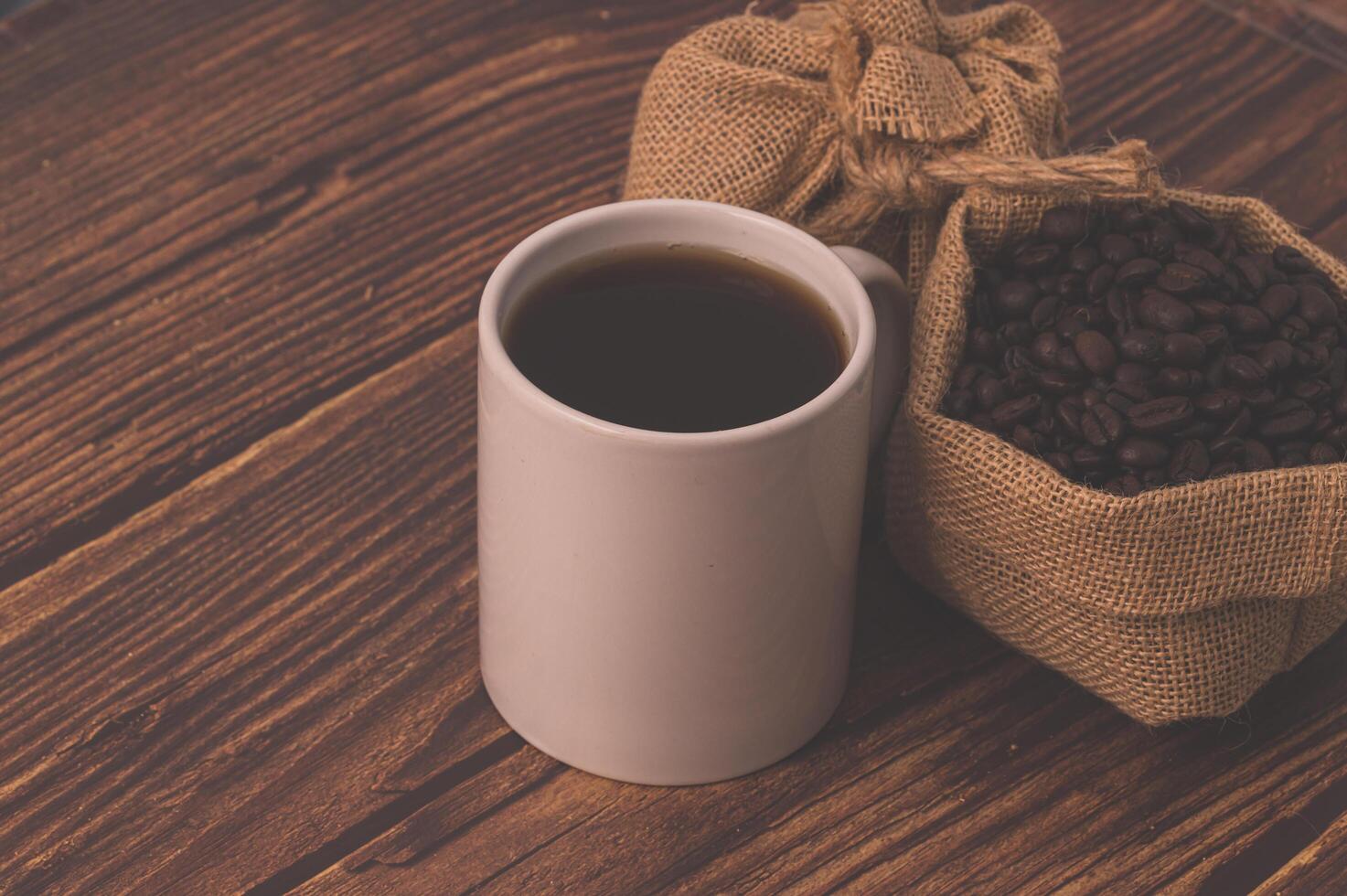 Granos de café en una mesa de madera, me encanta beber café concepto foto