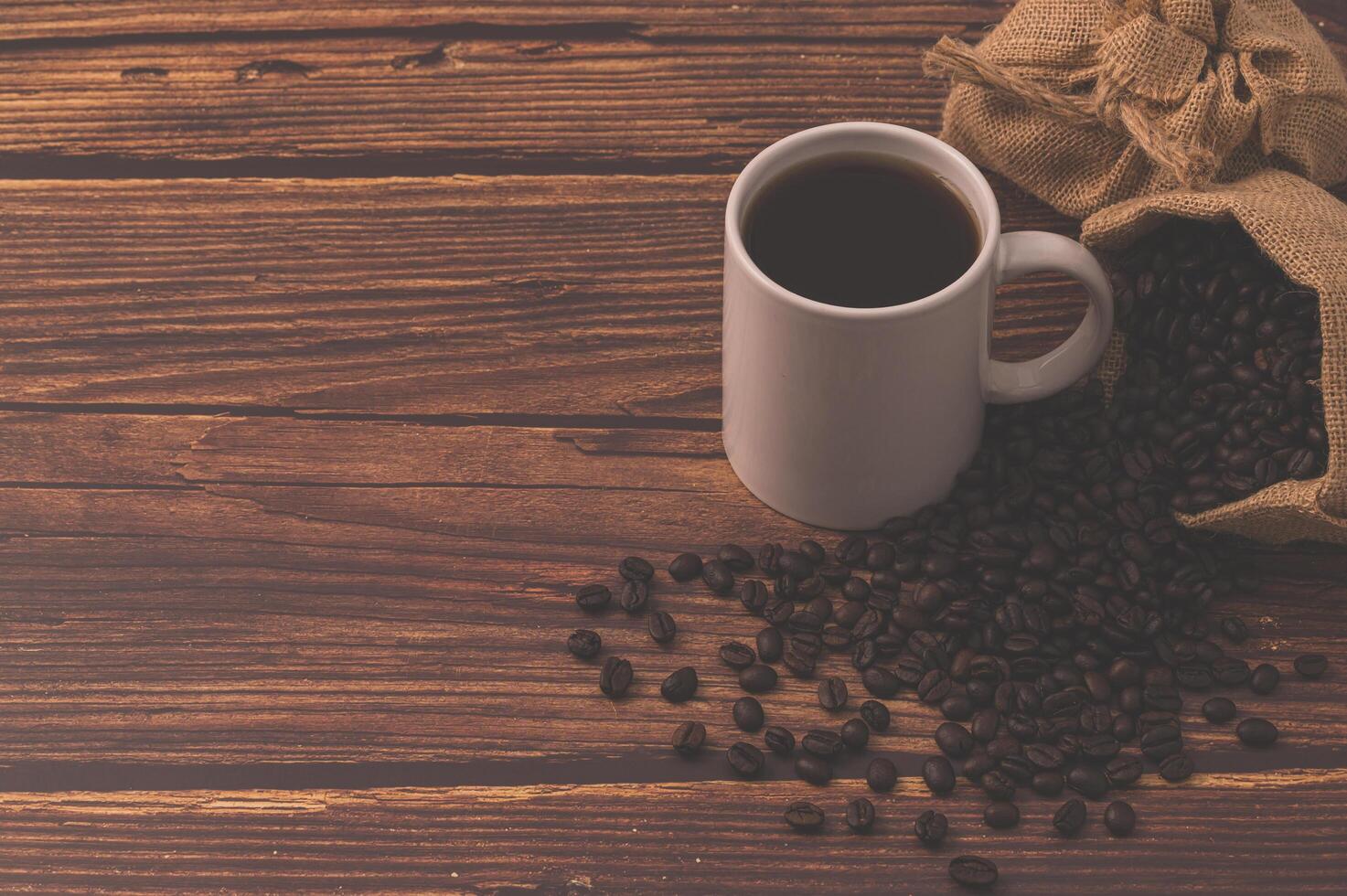 Granos de café en una mesa de madera, me encanta beber café concepto foto