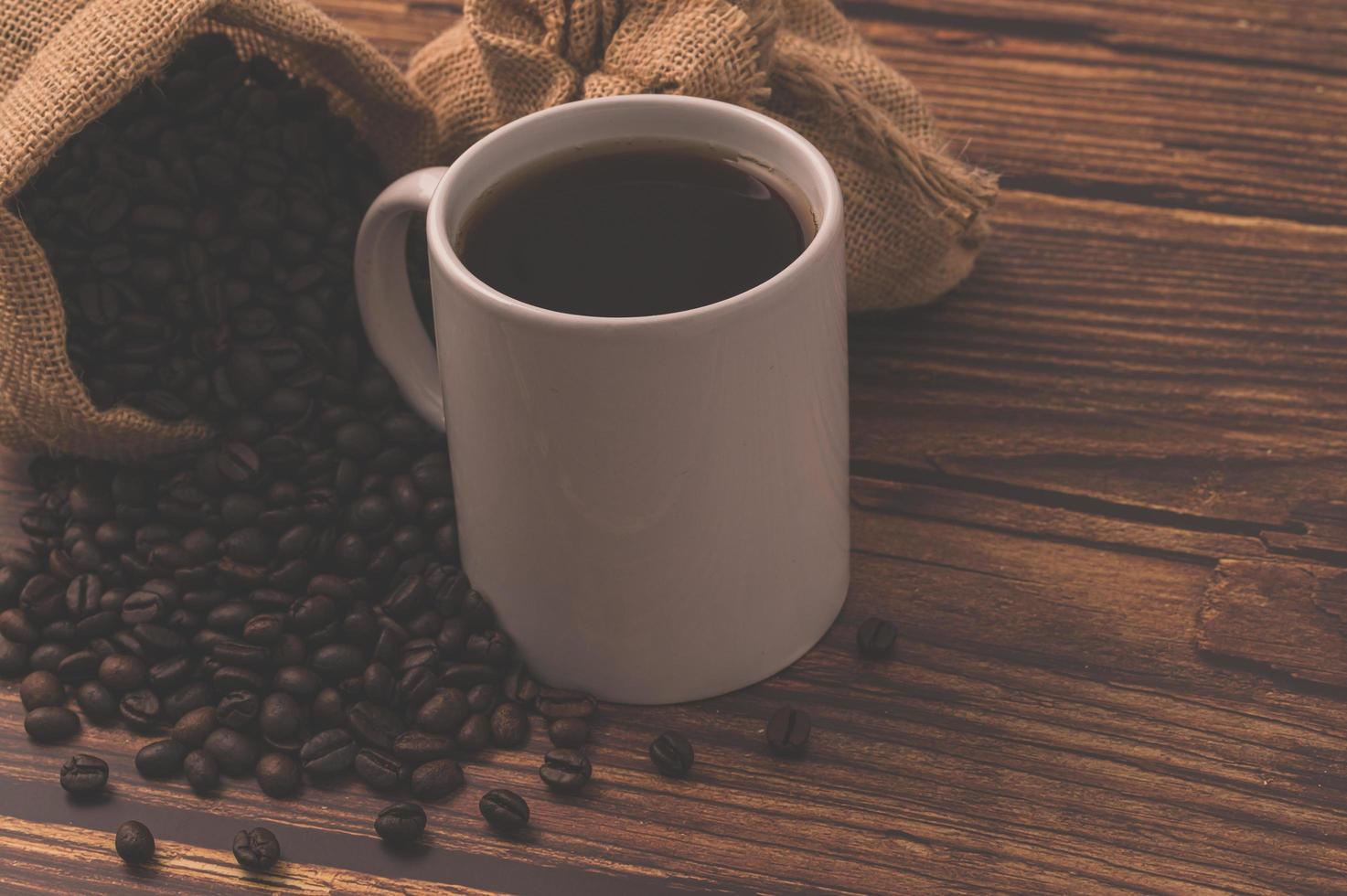 Granos de café en una mesa de madera, me encanta beber café concepto foto