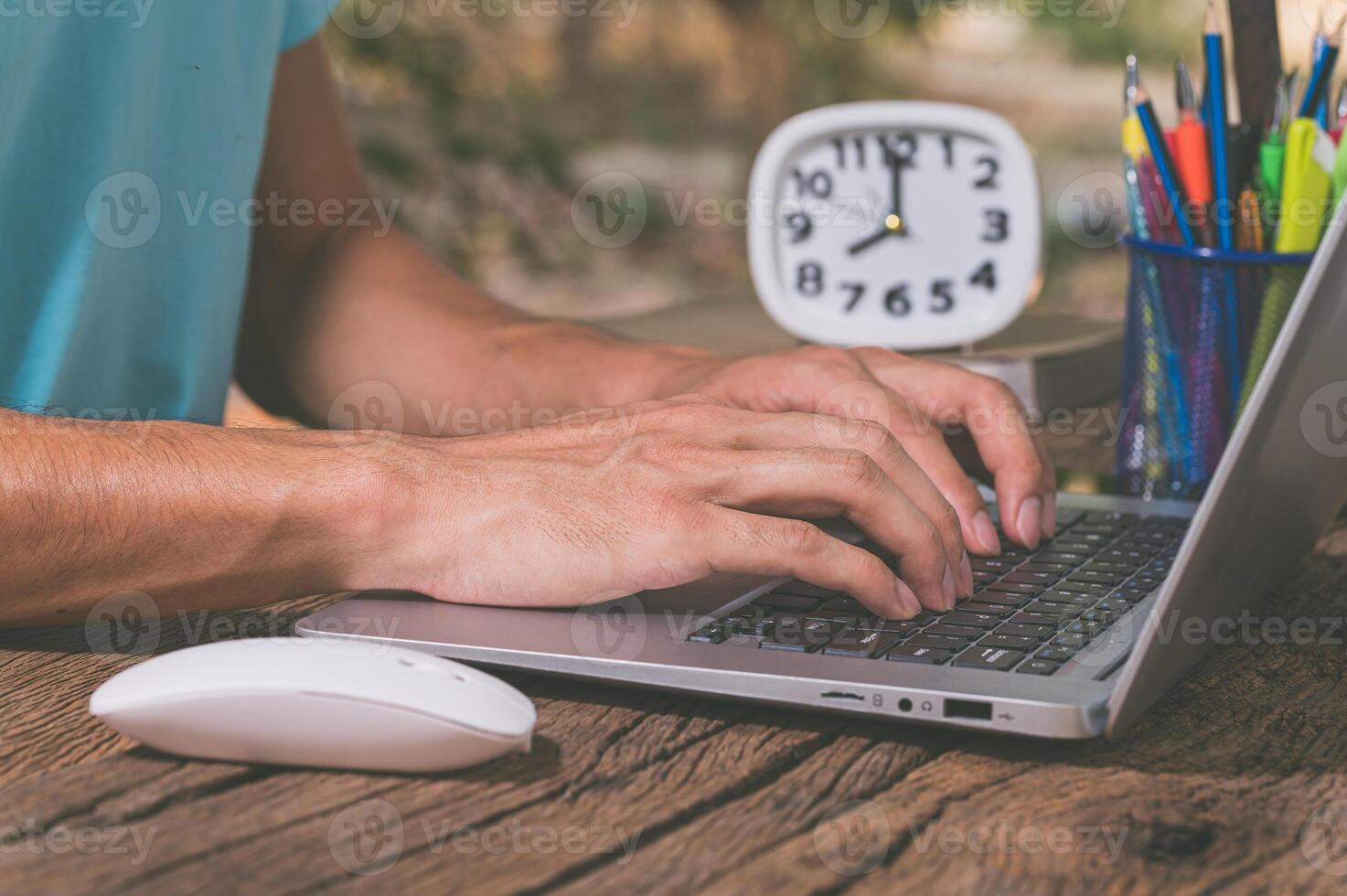 A man typing on a laptop computer photo