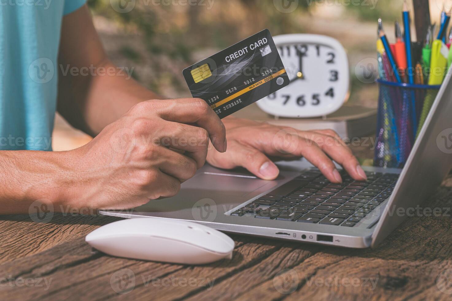 A man using a laptop and a credit card photo