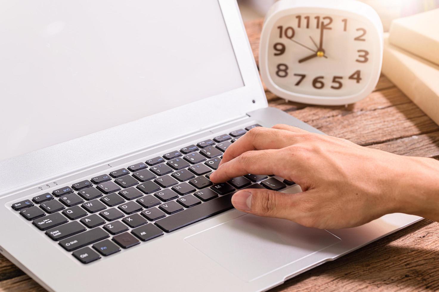 la mano de una persona usando una computadora portátil foto