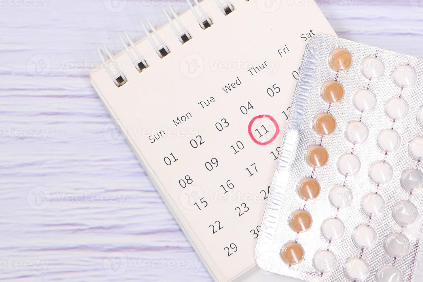 Birth control pills with a calendar photo