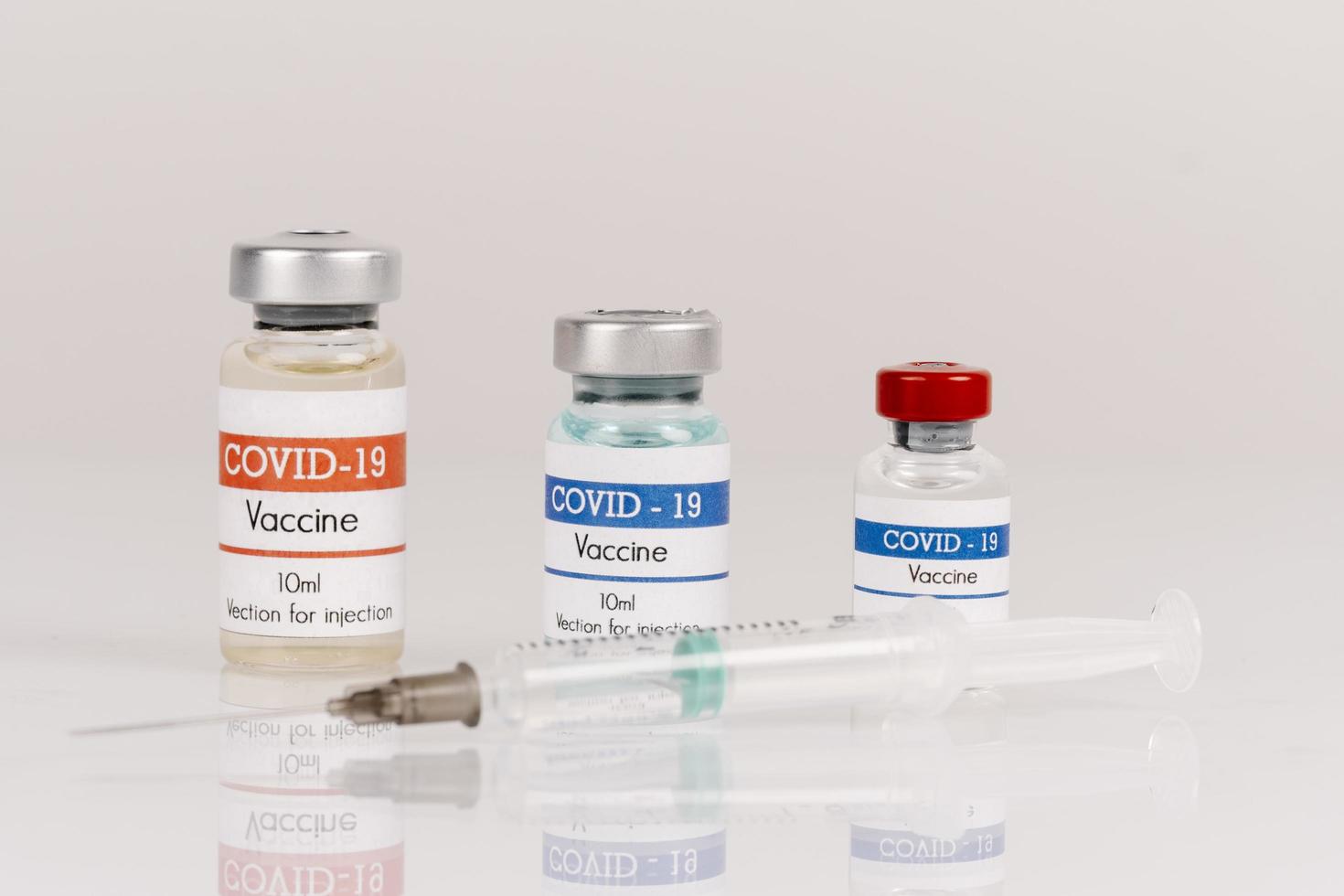 Covid-19 vaccine vials with syringe on a white background photo