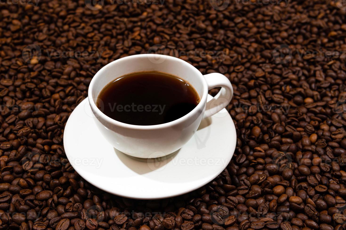 Taza de café con leche en el fondo de los granos de café foto
