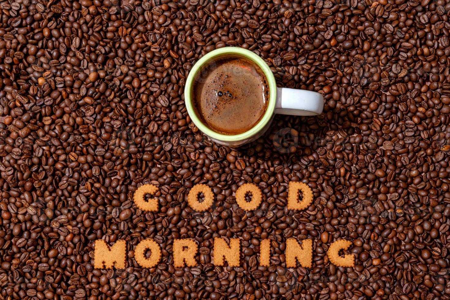 Taza de café blanco y palabras buenos días hechas de letras de galletas foto