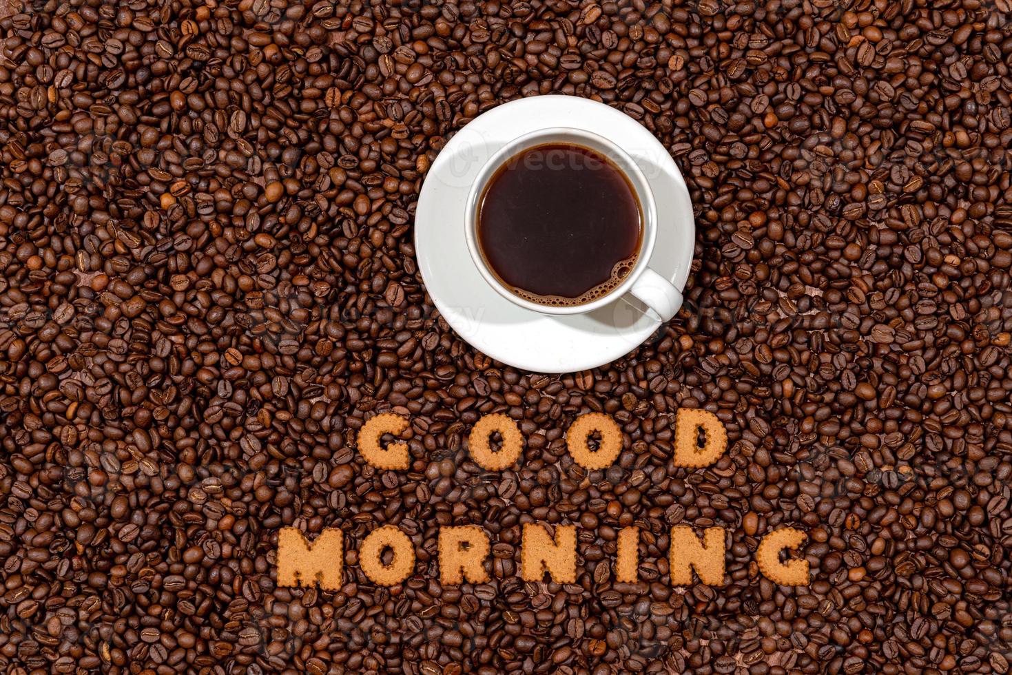 Taza de café blanco y palabras buenos días hechas de letras de galletas foto