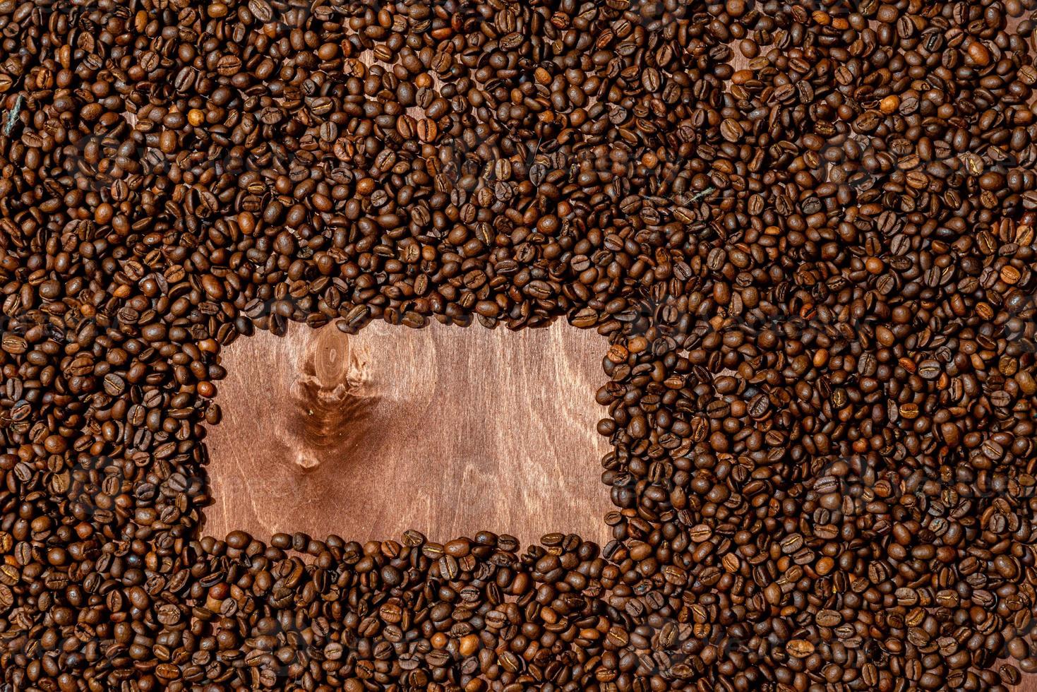 Textura de fondo de tablero de madera oscura y marco de granos de café foto
