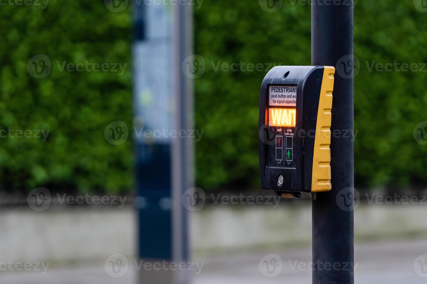 Crosswalk button for pedestrian with light warning on a defocused background photo