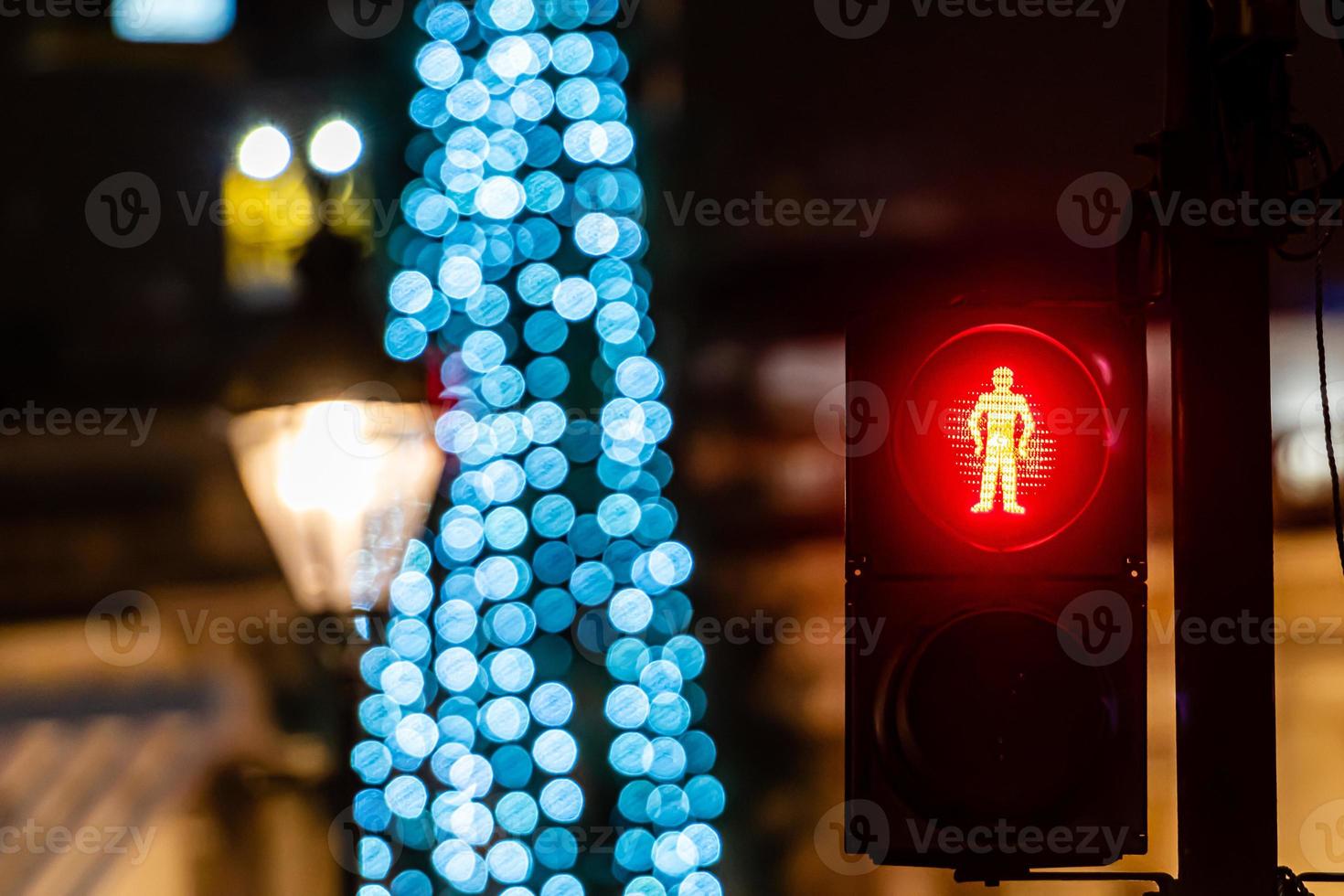 Pedestrian semaphore with green light and defocused Christmas tree lights photo
