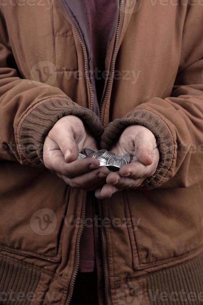 mendigo con monedas en las manos foto