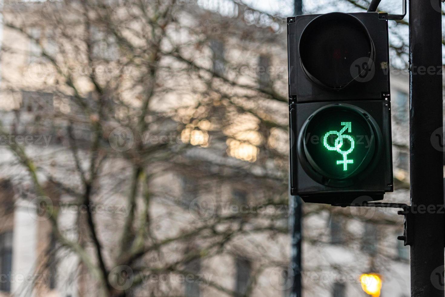 Semáforo peatonal con luz verde sobre fondo desenfocado foto