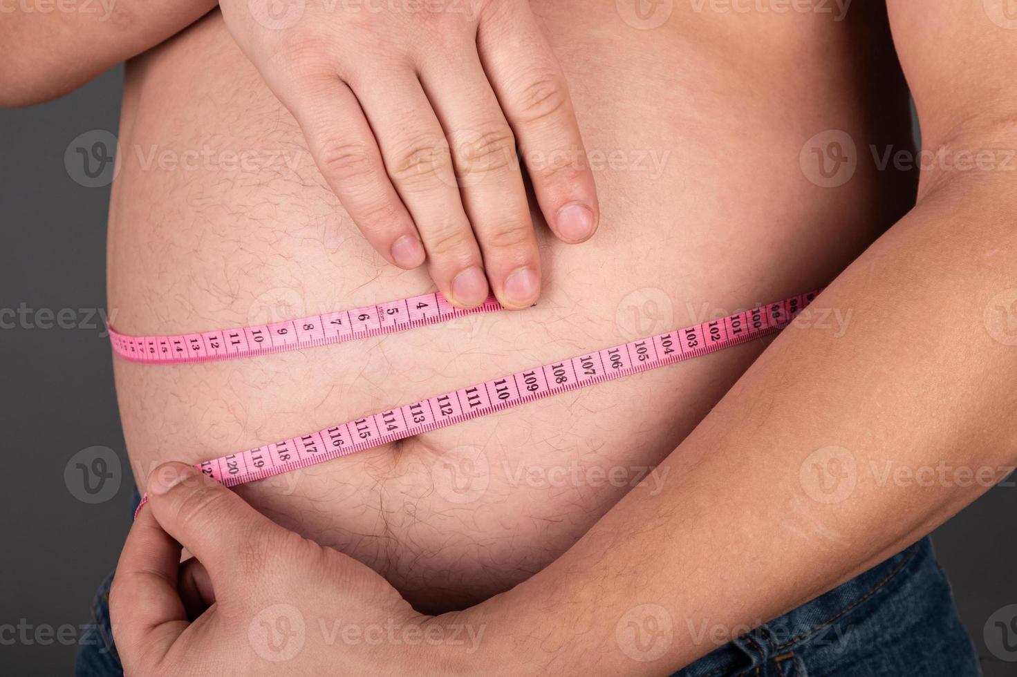 Measuring waistline of an overweight person photo