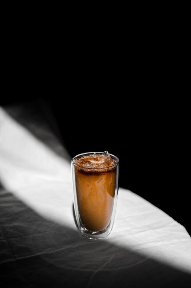 Vaso de café helado con leche en la mesa foto