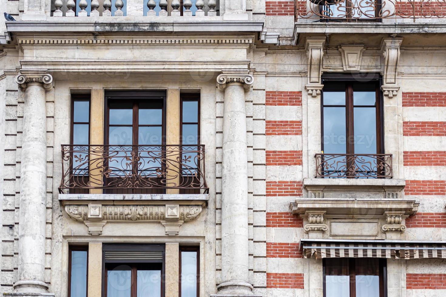 Fachada de un edificio histórico de ladrillo con balcones metálicos foto