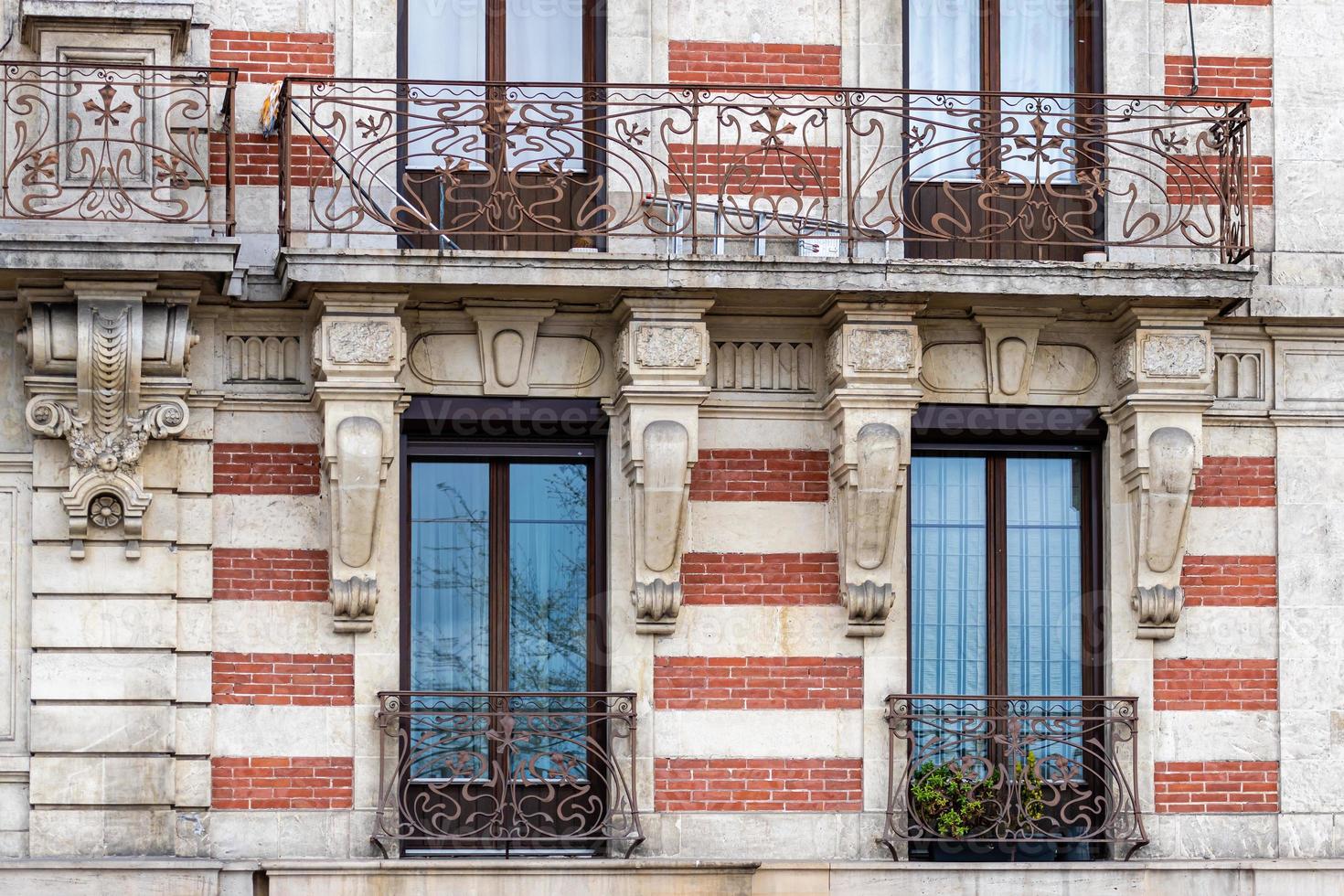 Facade of a historic brick building with metal balconies photo