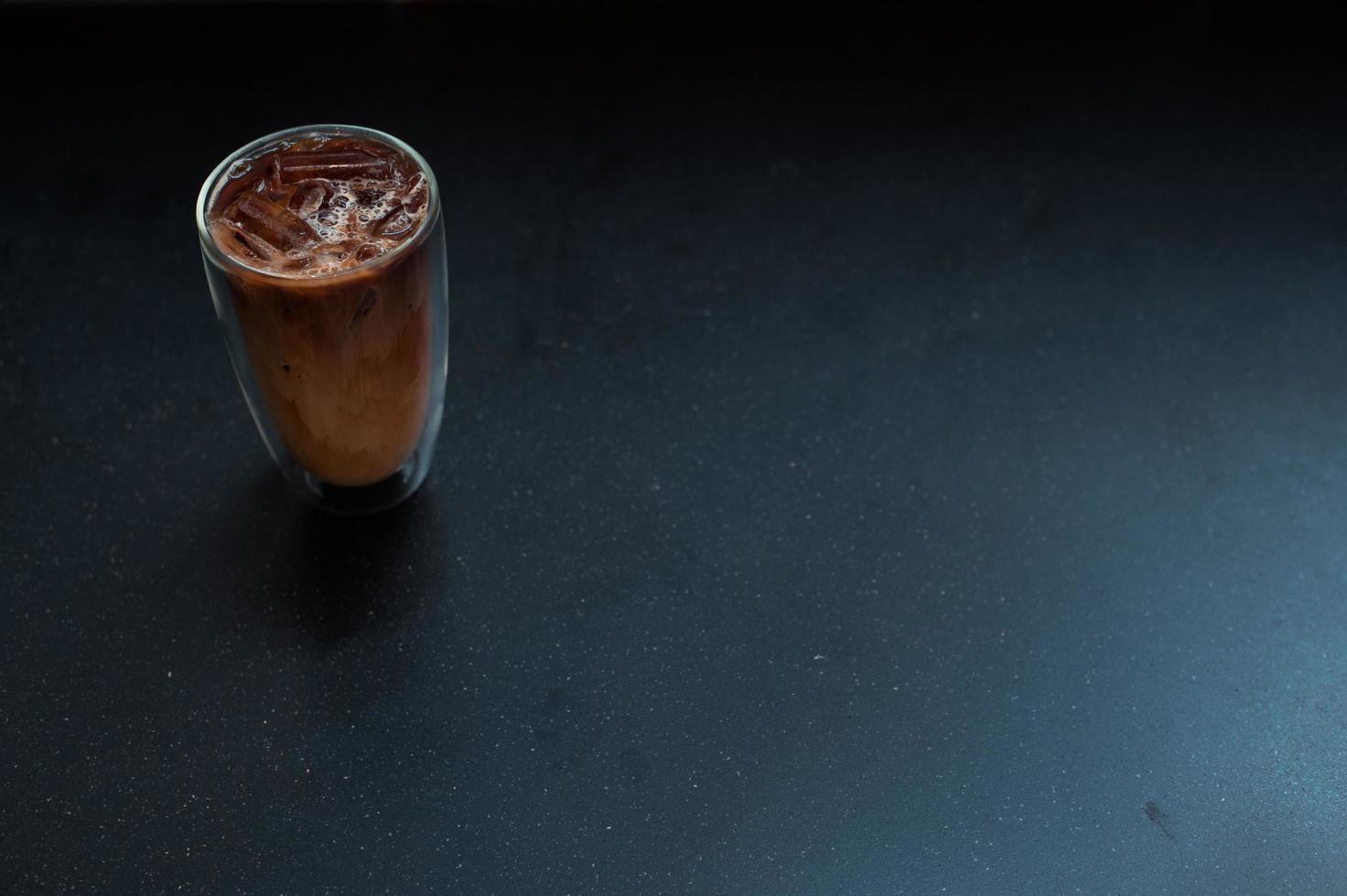 Vaso de café helado con leche en la mesa foto