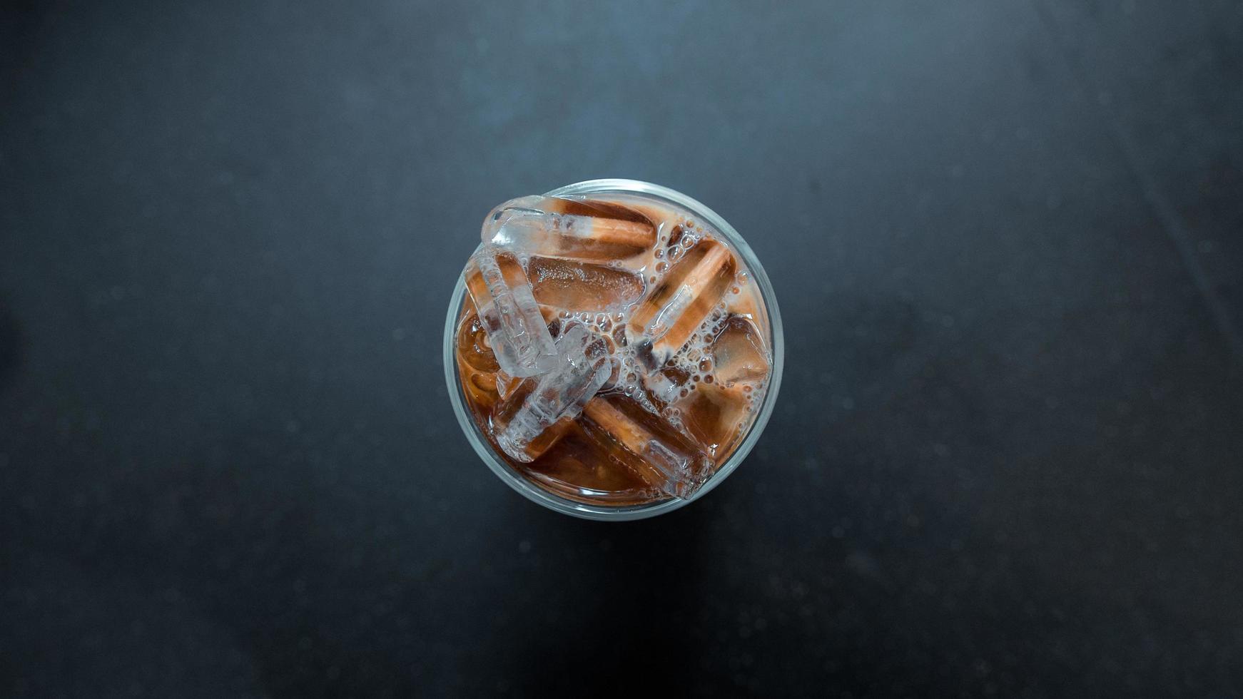 café helado con leche en una mesa oscura foto