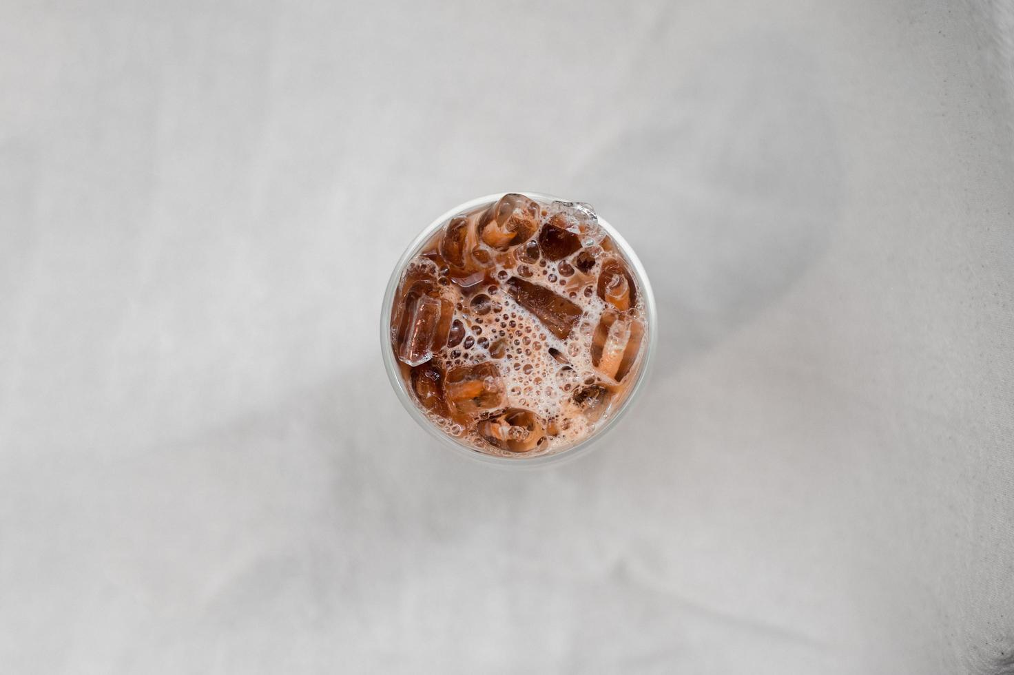 Iced coffee with milk on a white table photo