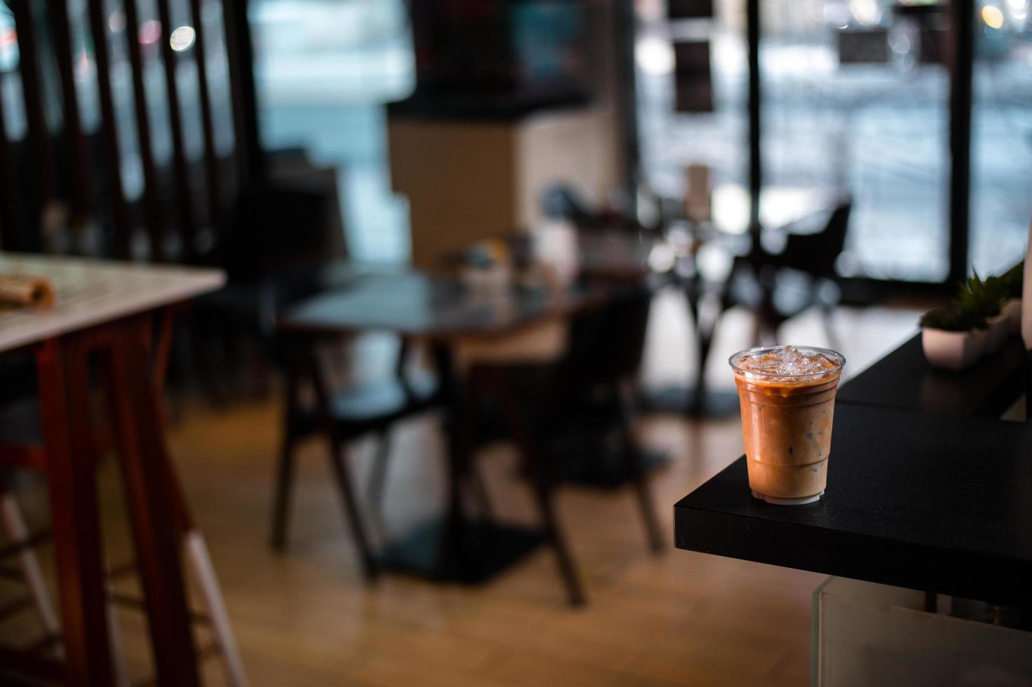 Close-up of glass of iced coffee with milk on a cafe table photo