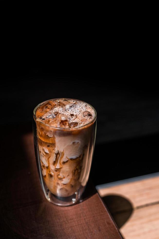 Close-up vaso de café helado con leche sobre la mesa foto