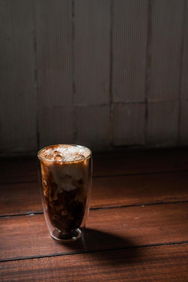 Close-up vaso de café helado con leche sobre la mesa foto