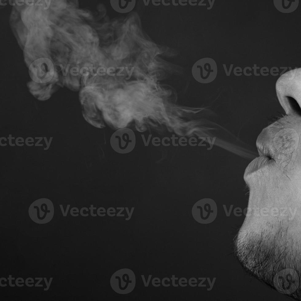 Man blowing cigarette smoke photo